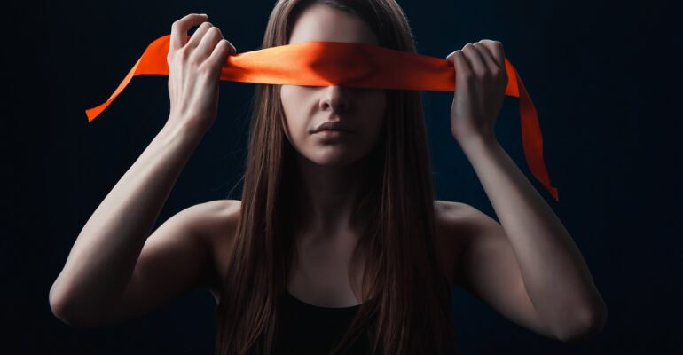 the girl blindfolded herself, with red tape, a game on a black background