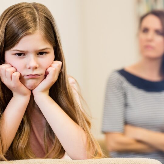 Daughter sitting upset with her mother in living room