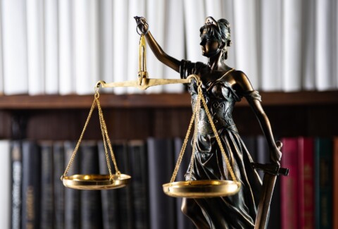 Scales of Justice, Lady Justice, law library concept, Law books in the background.