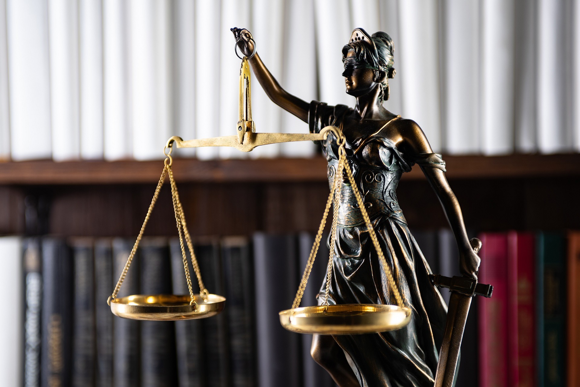 Scales of Justice, Lady Justice, law library concept, Law books in the background.