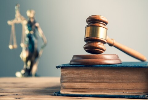 wooden judge on book with justice lady on desk