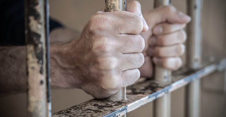 Close up of prisoner hands in jail