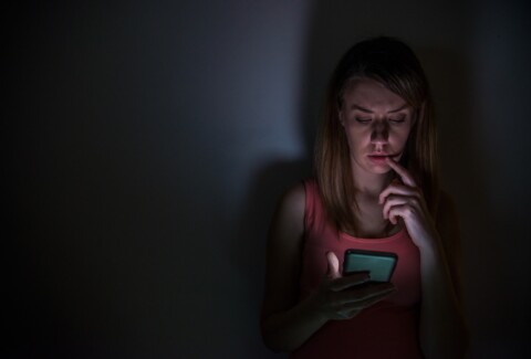 young sad vulnerable girl using mobile phone scared and desperat