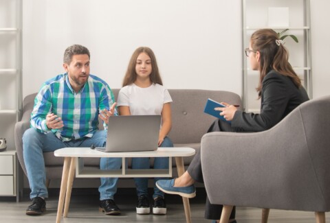 father and child at psychologist session. family therapy. parent-teacher meeting.