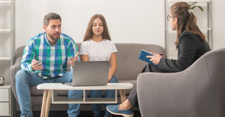 father and child at psychologist session. family therapy. parent-teacher meeting.